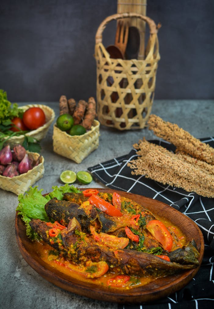 Delicious Lelemangut fish dish with fresh vegetables, beautifully presented on a rustic table.